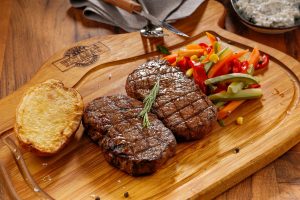 deux morceaux de steak sur une planche en bois