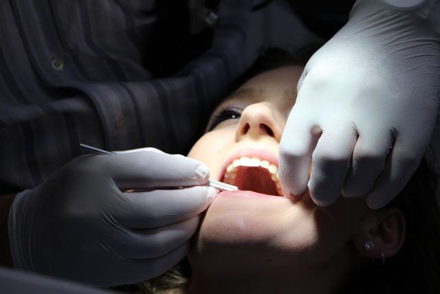 dentiste oscultant la bouche d'une femme