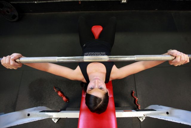 femme soulevant une barre au gym