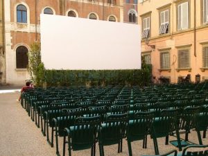 chaises vertes en ligne devant un écran de projection