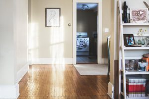 couloir de maison avec plancher en vois et murs beiges