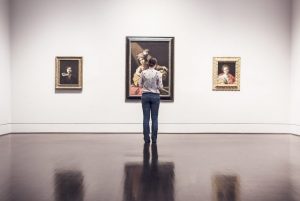 femme devant des peintures dans une salle