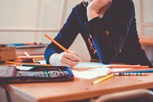 main d'enfant tenant un crayon sur une table 