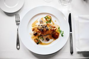 assiette blanche avec de la viande sur une table avec couverts