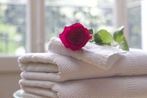 serviettes blanches pliées avec une rose dessus