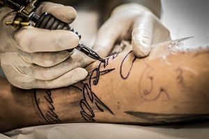 tatoueur faisant un tatouage sur un avant-bras