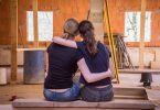 deux filles se prenant dans les bras devant un chantier