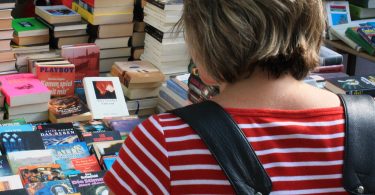 femme regardant un stand de livres