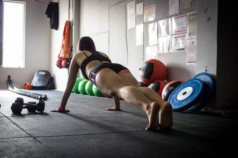 femme faisant des pompes en salle d'entrainement