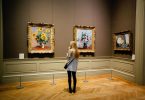 femme regardant des tableaux dans un musée