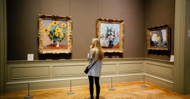 femme regardant des tableaux dans un musée