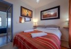 chambre a coucher avec lit et couverture rayée