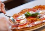 fourchette dans une pizza tomate et fromage