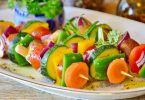 trois brochettes de legumes dans une assiette