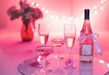 bouteille et duo de coupes de champagne sur fond rose